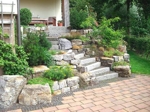 Neugestaltete Natursteintreppe mit Pflasterung.